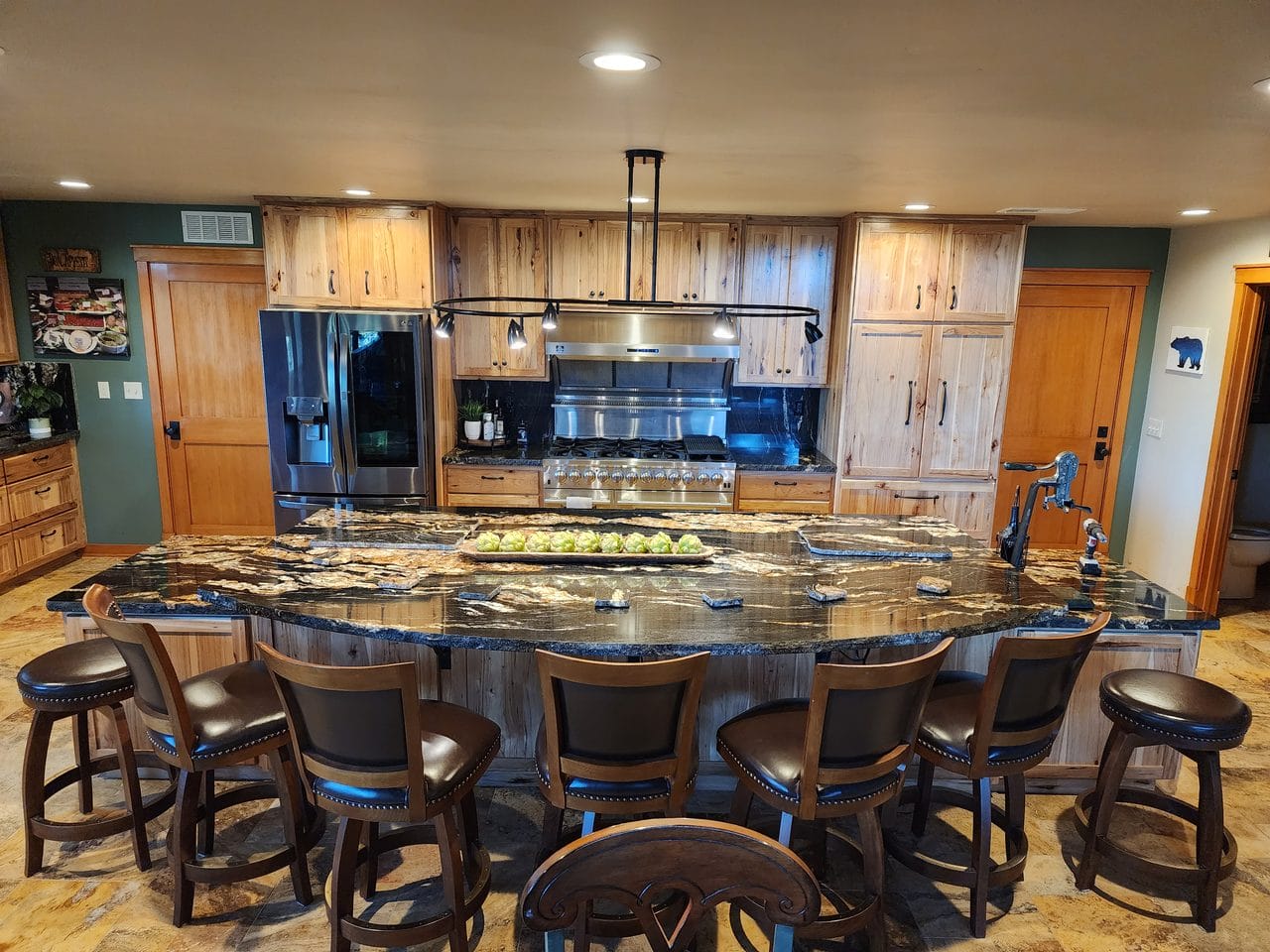 Kitchen with a large round granite island and bar stool seating