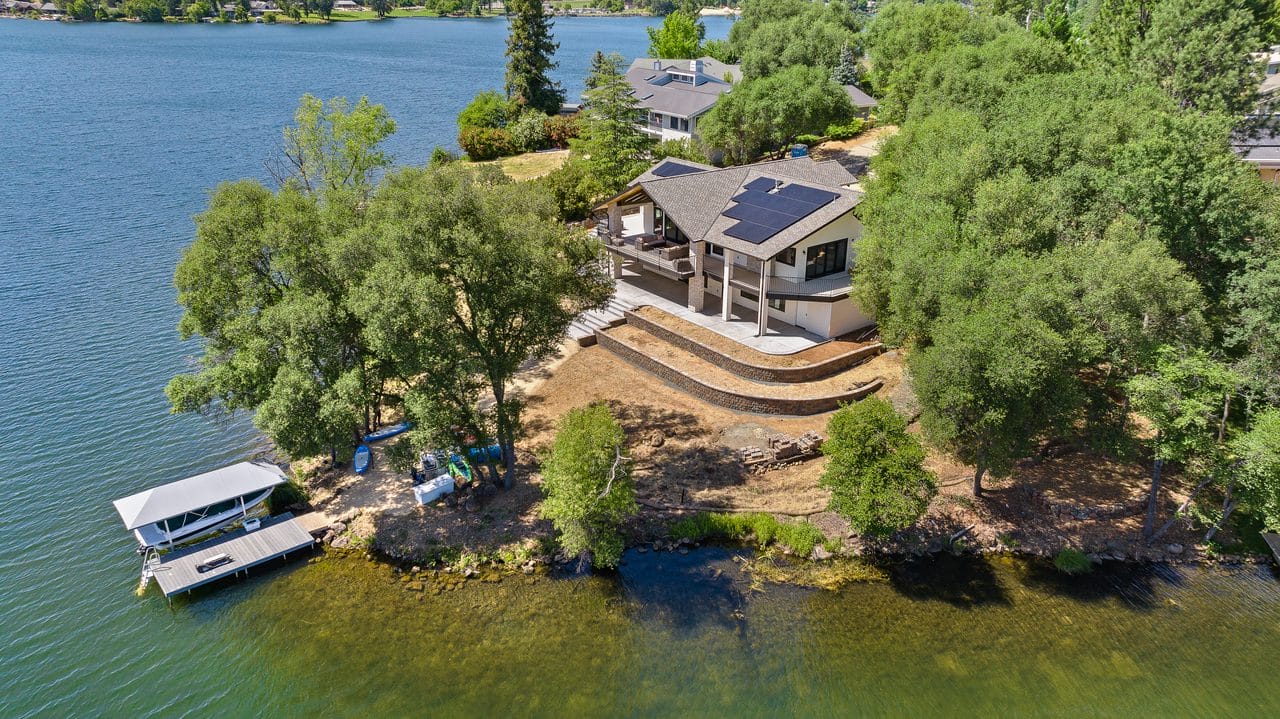 Aerial view of a lakefront home with a private dock among the trees