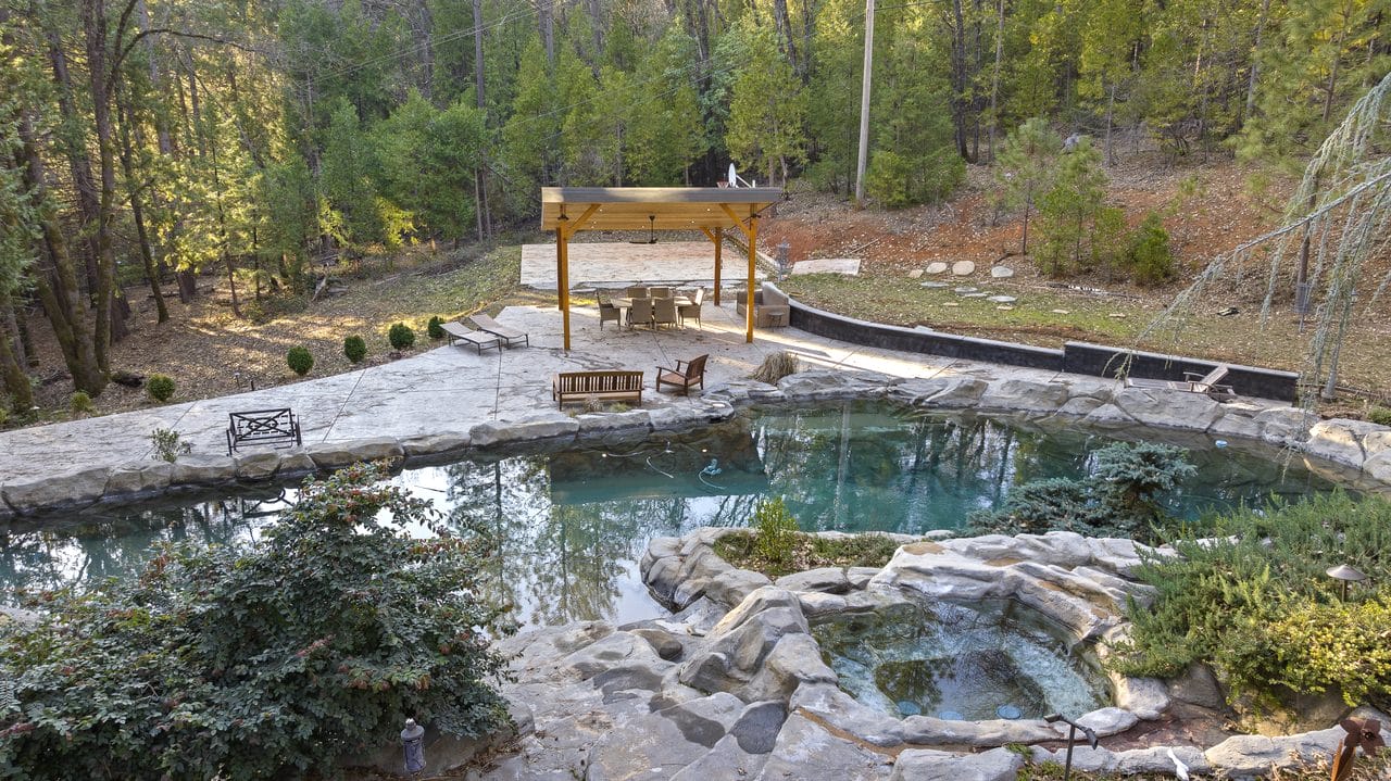 Natural rock-edged pool and pavilion set in wooded grounds