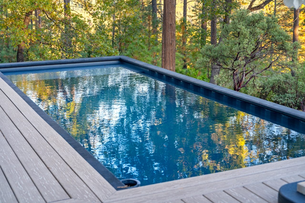 Rectangular pool with dark surround reflecting autumn foliage